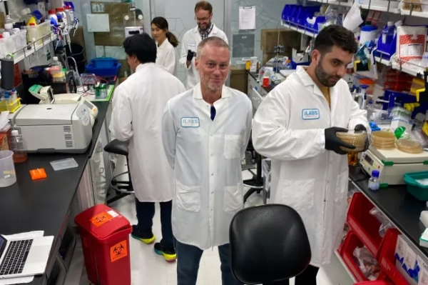 На цьому фото, наданому Centivax, Тім Фрід (у центрі) стоїть у лабораторії в Південному Сан-Франциско, Каліфорнія, у 2023 році, де його кров готує протиотруту від укусів різних змій. (Centivax via AP)